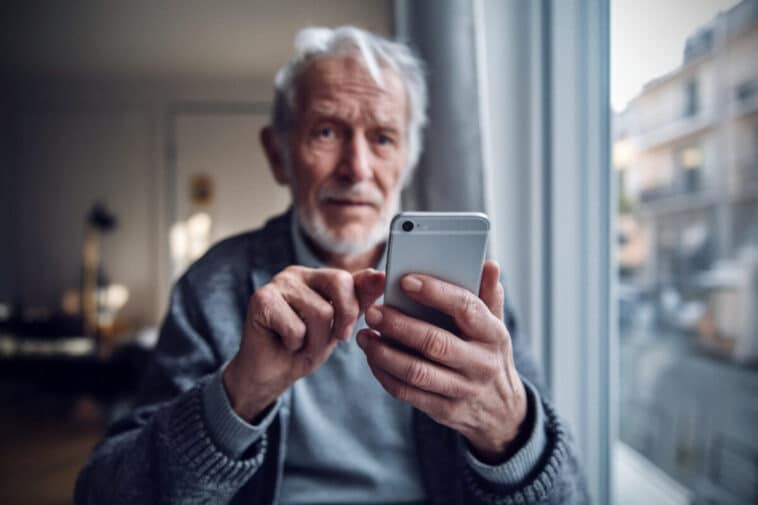 Un retraité consulte le versement Agirc-Arrco sur smartphone à domicile